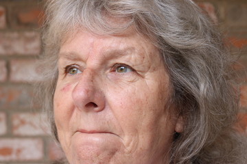 Portrait of a senior woman with clenched lips and a sad stare