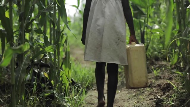 African Child Walking With Water