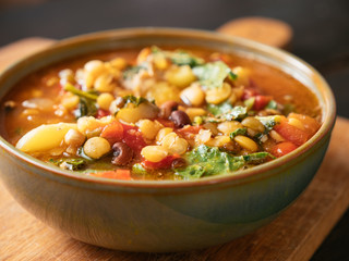 Bowl with a 5 bean soup with turnip greens.