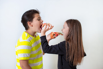 Little boy and girl eating pizza. The children have lunch