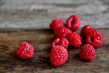 Tipped raspberries scattered on old wooden boards.