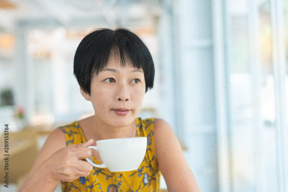 Wall mural asian woman hold a cup of coffee