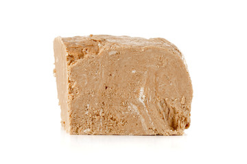 Halva on a white background. Arabian sweetness of caramel mass and ground roasted kernels of nuts, peanuts, close-up.