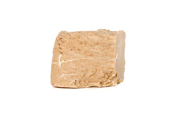 Halva on a white background. Arabian sweetness of caramel mass and ground roasted kernels of nuts, peanuts, close-up.