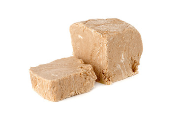 Halva on a white background. Arabian sweetness of caramel mass and ground roasted kernels of nuts, peanuts, close-up.