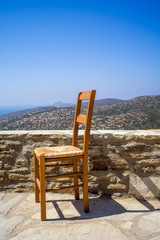 ein Stuhl vor blauem Himmel auf einem Balkon