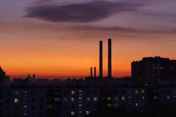 Fototapeta na wymiar Photography of the sleeping area of Moscow in the red sunset. View from above / top view. Chimneys of Heat station. Lifestyle of big city in summer time.