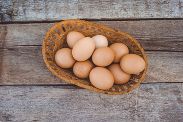 Beautiful chicken eggs in a wicker basket on a wooden Board.