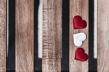 Red Hearts and White Heart on Wooden Background. Valentine's Day Concept. Copy Space.
