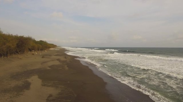 aerial view sandy beach near ocean with big waves at sunset time in tropical resort, Yogyakarta, Indonesia. seascape, ocean and beautiful beach. Travel concept. Indonesia, java