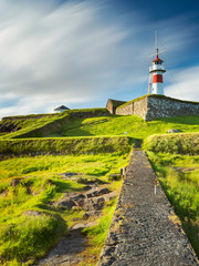 Fototapeta na wymiar long exposure of clouds above lighthouse in summer day in capital of Faroe island