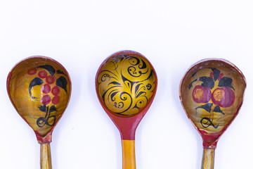 Old wooden spoons, painted in Khokhloma style. Isolated on white.