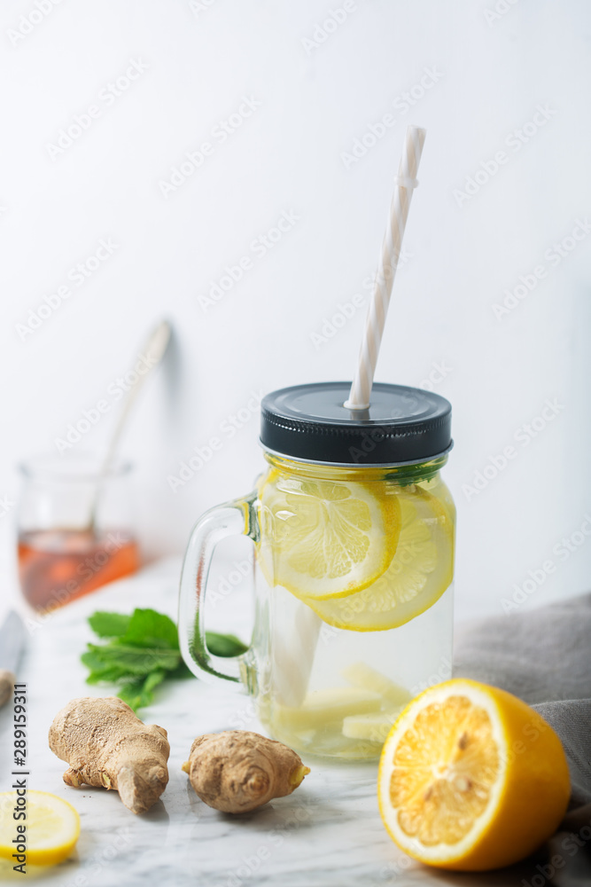 Wall mural ginger water in glass jar with lemon and honey, vertical orientation, white background