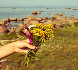 Fototapeta na wymiar girl holding a bouquet of wildflowers .