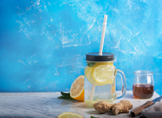 Ginger Water in Glass jar With Lemon and Honey on Blue Background With Copy Space