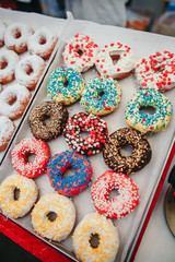 Assorted donuts with chocolate frosted, pink glazed and sprinkles donuts. Food donut desert sweets.