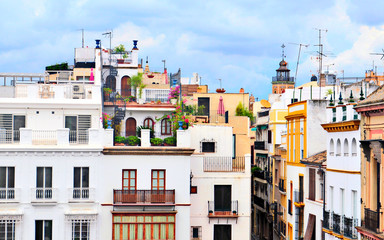 Facades of old houses in various colors in Seville the capital city of Andalucia in Spain in a cloudy day.