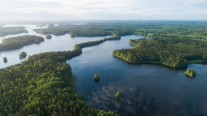 Fototapeta na wymiar Lake system surrounded with green forest in Finland, aerial landscape. Nature exploration concept.