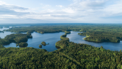 Beautiful lakes and green forest at bright sunrise. Morning in countryside concept. Aerial panorama.