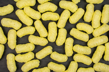 Lot of whole salted yellow corn puff flatlay on grey stone