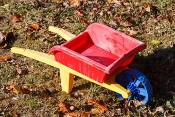 Outdoor toy, red and yellow wheelbarrow in plastic