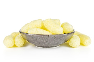 Lot of whole salted yellow corn puff in dark ceramic bowl isolated on white background