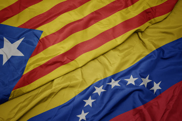 waving colorful flag of venezuela and national flag of catalonia.