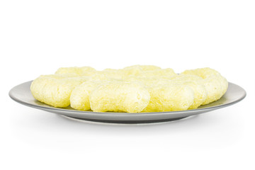 Lot of whole salted yellow corn puff on gray ceramic plate isolated on white background