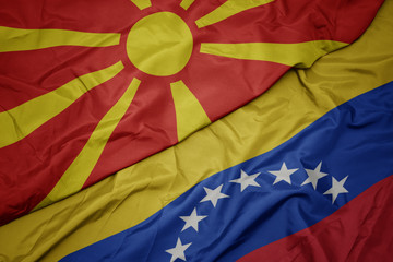 waving colorful flag of venezuela and national flag of macedonia.
