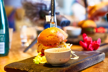 Burger is on a wooden Board in the restaurant