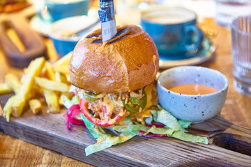 Burger is on a wooden Board in the restaurant