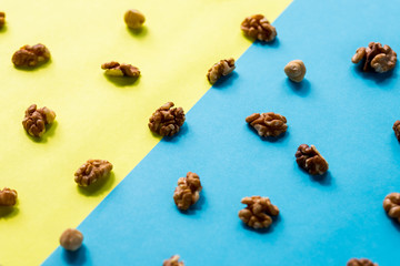 Isolated nuts pattern backdrop. Walnut, cashew, almond and hazelnut on colorful background. Top view.Flat lay composition of different nuts and nuts on yellow blue background.
