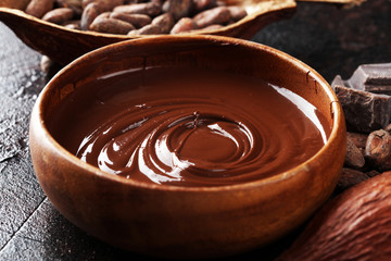 Melting chocolate, melted chocolate and chocolate swirl with stack and chips on table