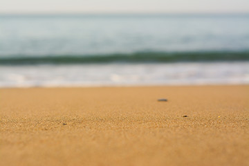 Fototapeta na wymiar Yellow sand on a blurred background of the sea