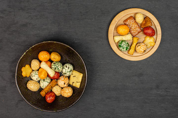 Lot of whole rice japan assortment on round bamboo coaster in dark ceramic bowl flatlay on grey stone