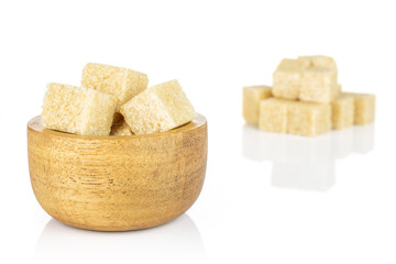 Lot of whole sweet brown sugar cube in tiny wooden bowl isolated on white background