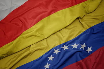 waving colorful flag of venezuela and national flag of south ossetia.