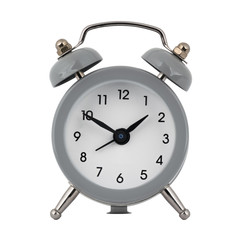 A gray clock with an alarm clock on a white background with arrows showing the time one hour fifty minutes or thirteen hours and fifty minutes