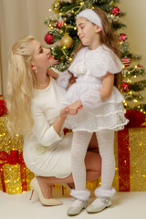 Obraz na płótnie Canvas Mom with a little daughter at the Christmas tree.