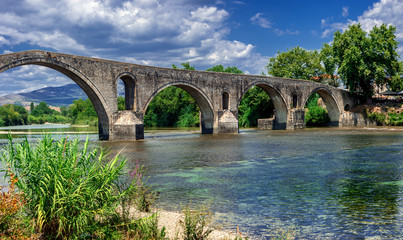 Fototapeta na wymiar The historic stone bridge of Arta at the banks of Arachthos river in Epirus Greece on a summer day (west view)