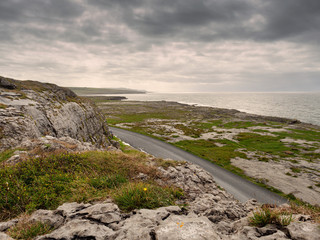 Landscape view in Burren National park, Atlantic ocean, Small road, rough terrain, dramatic sky, Part of Wild Atlantic Way.