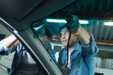 mechanic changing glass on car in his workshop