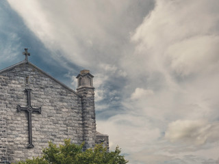 Wall of Galway Cathedral with crosses on a bright dramatic sky background. Ireland.