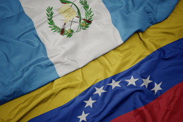 waving colorful flag of venezuela and national flag of guatemala.