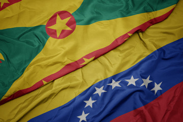waving colorful flag of venezuela and national flag of grenada.