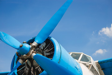 Close up abstract of a vintage airplane propeller engine against blue sky, closeup. Travel concept