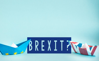 Brexit UK EU concept - paper ships from the flags of the European Union and the UK on a blue background
