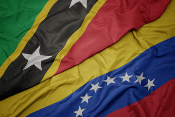 waving colorful flag of venezuela and national flag of saint kitts and nevis.