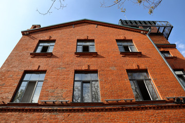 Building of bright orange brick on a background of blue sky in the daytime