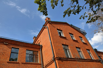 Building of bright orange brick on a background of blue sky in the daytime